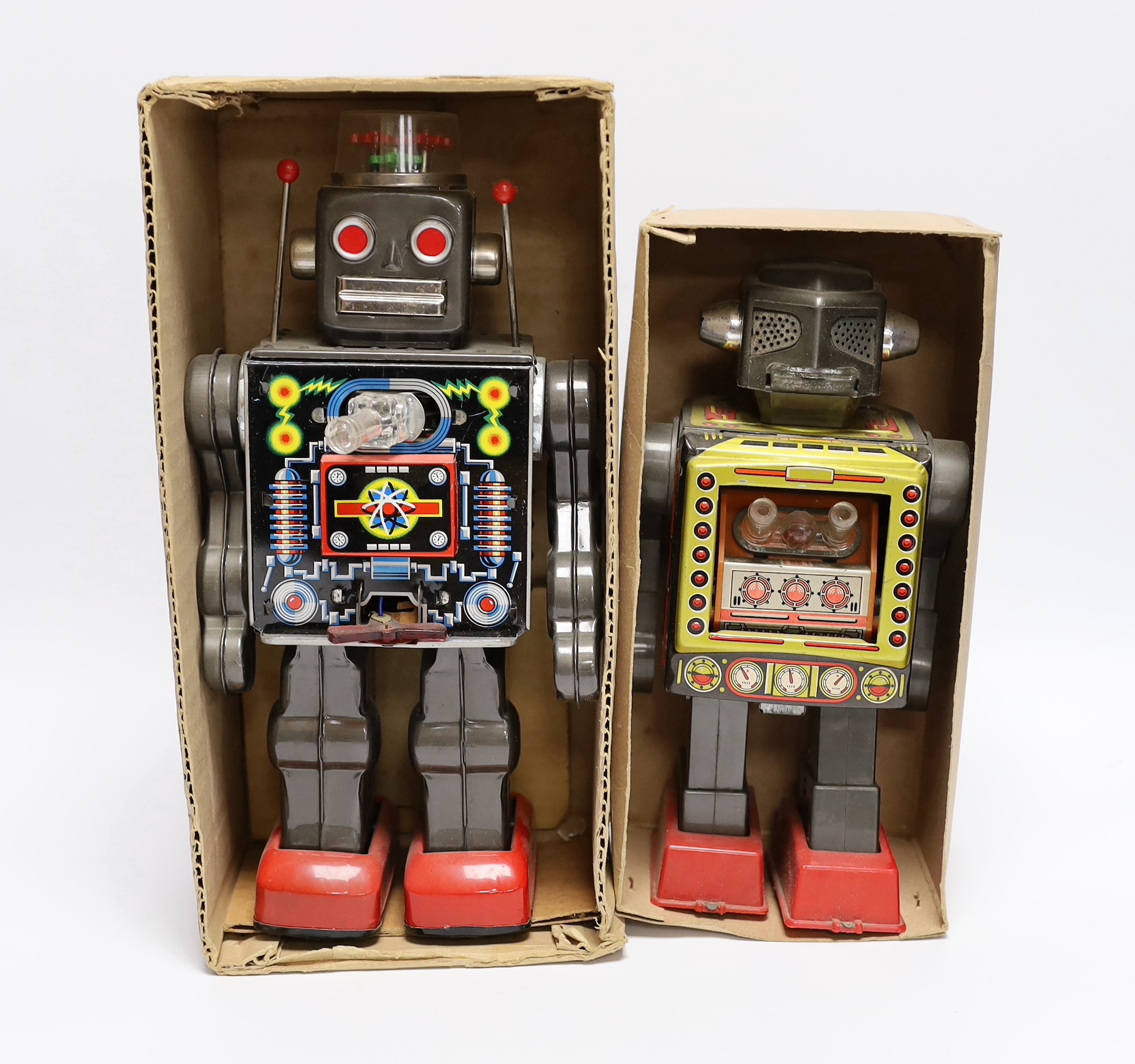 Four 1960s Japanese battery and clockwork powered robots, including; a boxed Horikawa (SH Toys) Fighting Robot, another smaller example by Horikawa, a Yoshiya (KO) silver robot and a Yoshhiya black clockwork robot, talle